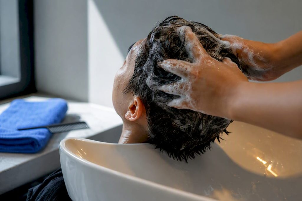 Hair being carefully cleansed at wash station